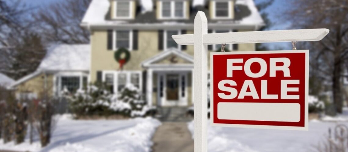 Home For Sale Sign in Front of Snowy New House